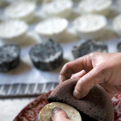 Preparing Le Roi Noir by coating at Monteillet Fromagerie, Photo by Steve Scardina