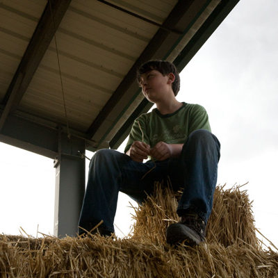 Boy on Hay Bales - Farm Stay Photo by Steve Scardina.