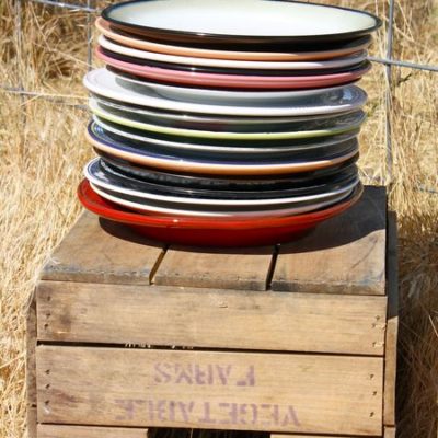 photo of plates stacked on wooden crate—2011 Outstanding in the Field Dinner—photo by The Farm Chicks