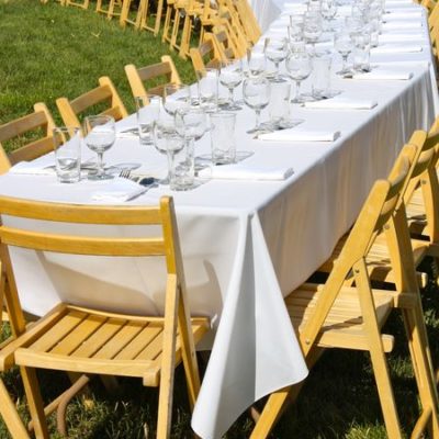 photo of table set with white cloth—2011 Outstanding in the Field Dinner—photo by The Farm Chicks