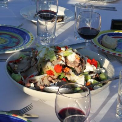 photo of salad and glasses of wine on table—2011 Outstanding in the Field Dinner—photo by The Farm Chicks