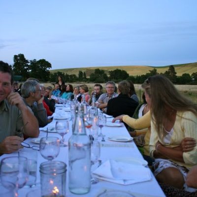photo of people in conversation around the table—2011 Outstanding in the Field Dinner—photo by The Farm Chicks
