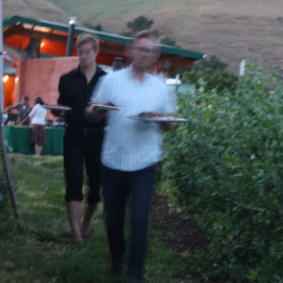 photo of dinner being served—The chef (second from right) and crew—2011 Outstanding in the Field Dinner—photo by The Farm Chicks